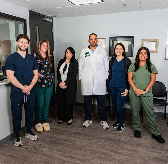 Full team photo of Dr. Yousif Orthopedic Surgery staff, including Dr. Yousif (center) and the clinical and administrative members, standing in the office waiting area.