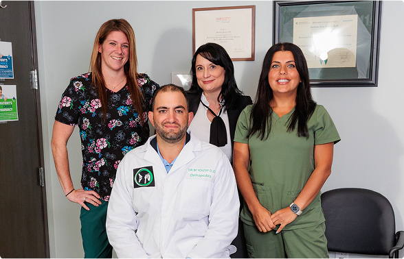 Group photo of the dedicated staff team at Yousif Orthopedic Surgery, featuring Dr. M Yousif, D.O. in his white coat.